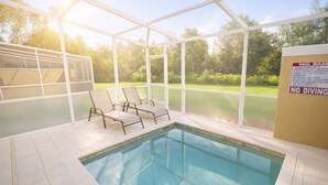 Une piscine intérieure avec des parois en verre transparent, un espace aménagé au bord de la piscine avec des chaises longues, et un panneau indiquant qu’il est interdit de plonger.