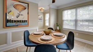 A dining area with a round table, blue chairs, and a ceiling fan. - Walk to restaurants! 10min to beaches and downtown Charleston.  (Mount Pleasant)