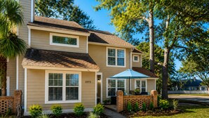 A two-story house with a number '1075' on the front, a brick entryway, and a small front yard with plants and a pathway. - Walk to restaurants! 10min to beaches and downtown Charleston.  (Mount Pleasant)