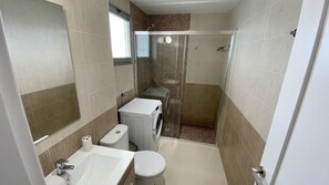 A compact bathroom with a toilet, sink, and shower. - Nice apartment on the beach with a large terrace facing the sea (La Garita)