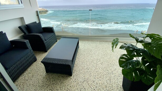 Ein Balkon mit Meerblick, ausgestattet mit einer Sitzecke, zwei Sofas und einem Couchtisch.