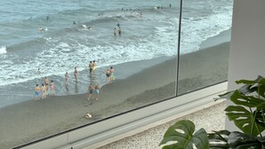 Ein Strand mit badenden und Spaziergängern am Ufer.