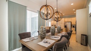 Un coin repas comprenant une table en bois, six chaises et des vases décoratifs.
