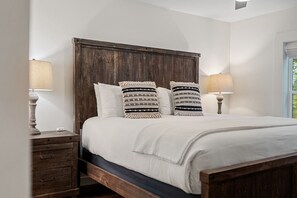 A bed with a wooden headboard, two bedside lamps, and a window with a view. - YARD/Hot Tub/Game Room/Theater/VIEWS/Fire Pit - Garrett Lodge (Gatlinburg)