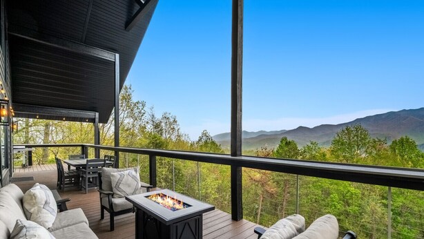 Eine Terrasse mit Gartenmöbeln, einem Feuerkorb und einem malerischen Bergblick.