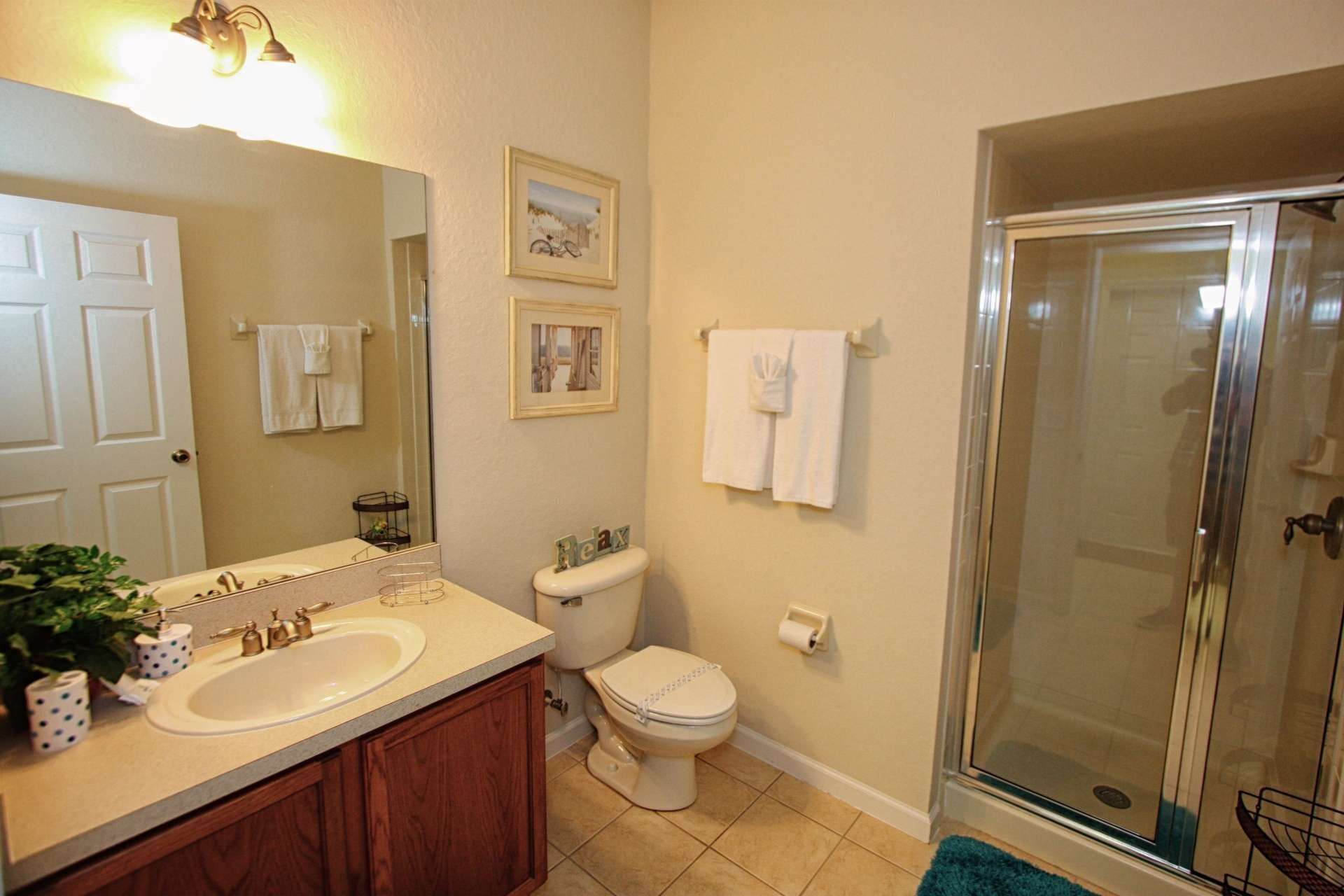 A bathroom with a sink, toilet, and shower.