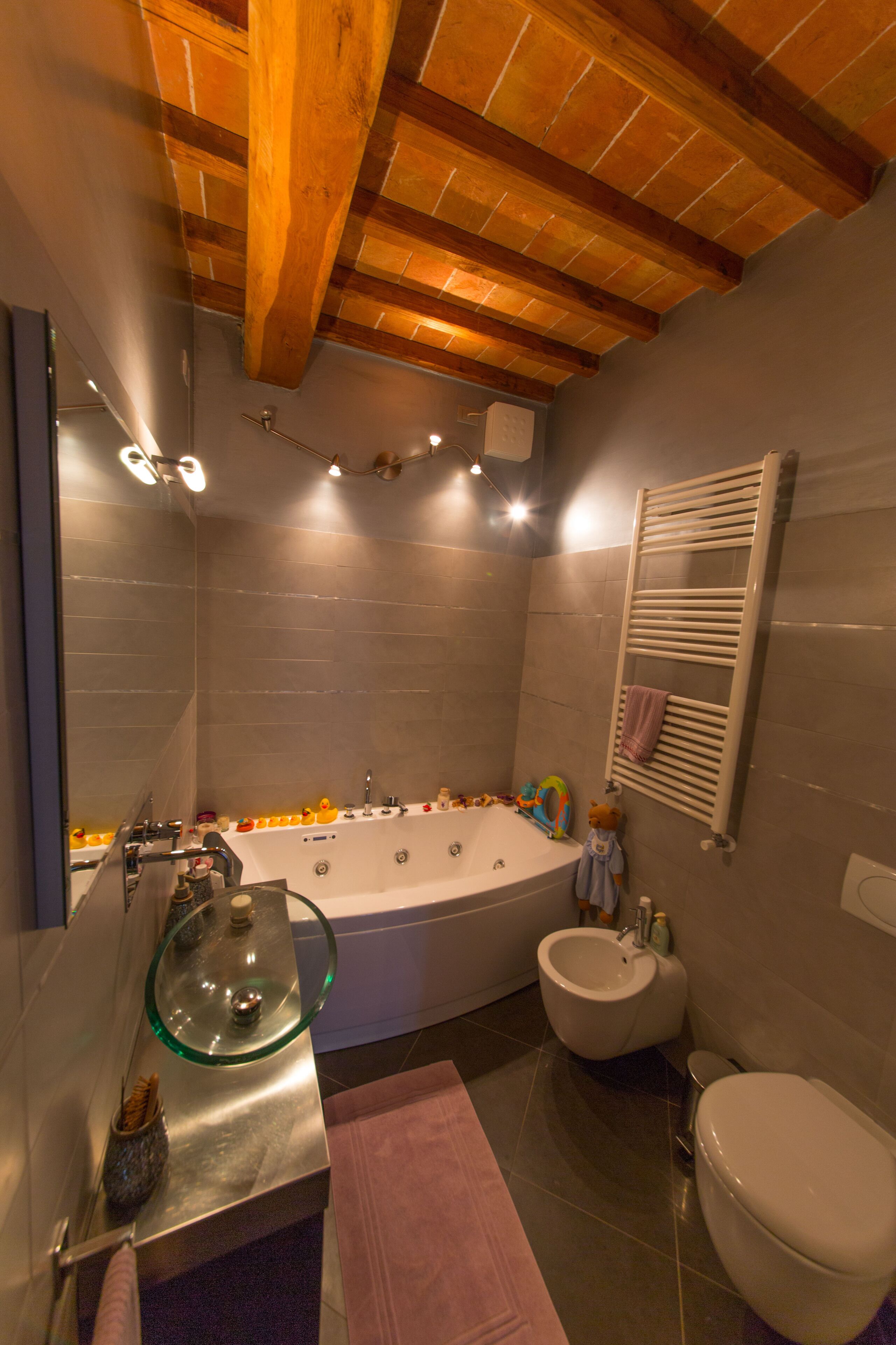 Un baño moderno con una bañera acristalada, un inodoro separado y un bidé.
