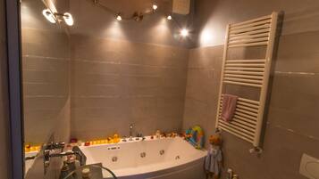 Un baño moderno con una bañera acristalada, un inodoro separado y un bidé.