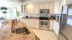 A modern kitchen with granite countertops, stainless steel appliances, and light-colored cabinetry. - 🏖️Fabulous Ocean Views in Belmont Towers on Boardwalk. AC, Pool, Gym🏖️ (Ocean City)
