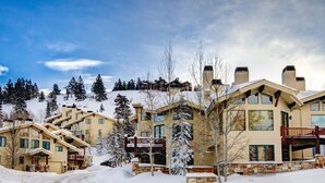 A snow-covered resort with multiple buildings, a ski lift in the background, and a clear sky. - Modern Ski-in/Ski-out in Silver Lake. Fully Remodeled. Steps to the slopes!!! (Deer Valley)