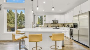 A modern kitchen with white cabinets, stainless steel appliances, and a large island with bar stools. - Modern Ski-in/Ski-out in Silver Lake. Fully Remodeled. Steps to the slopes!!! (Deer Valley)