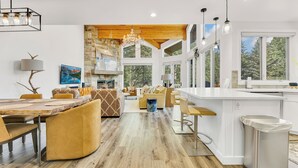 A spacious kitchen with a central island, wooden flooring, and large windows offering views of the outdoors. - Modern Ski-in/Ski-out in Silver Lake. Fully Remodeled. Steps to the slopes!!! (Deer Valley)
