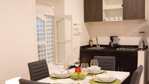 A dining area with a table set for four, including plates, glasses, and a fruit bowl. - BEAUTIFUL APARTMENT STUDIO IN HISTORICAL CENTER  (Cartagena)
