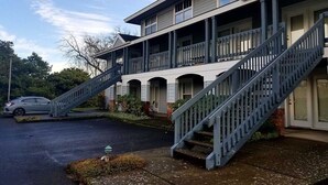 A two-story building with a covered front porch and a staircase leading to the entrance. - Enjoy the View - 2 Bedrooms, 2 Bathrooms - Upstairs Condo Blocks from Downtown (Hood River)