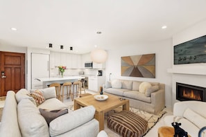 A modern living room with a sofa, a coffee table, and a fireplace.
