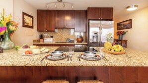 A modern kitchen with granite countertops, stainless steel appliances, and wooden cabinets.