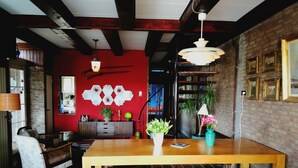 A dining area with a wooden table, bench, and potted plants. - 6-10 pers family home in the country, 15km from Amsterdam (Wijdewormer)