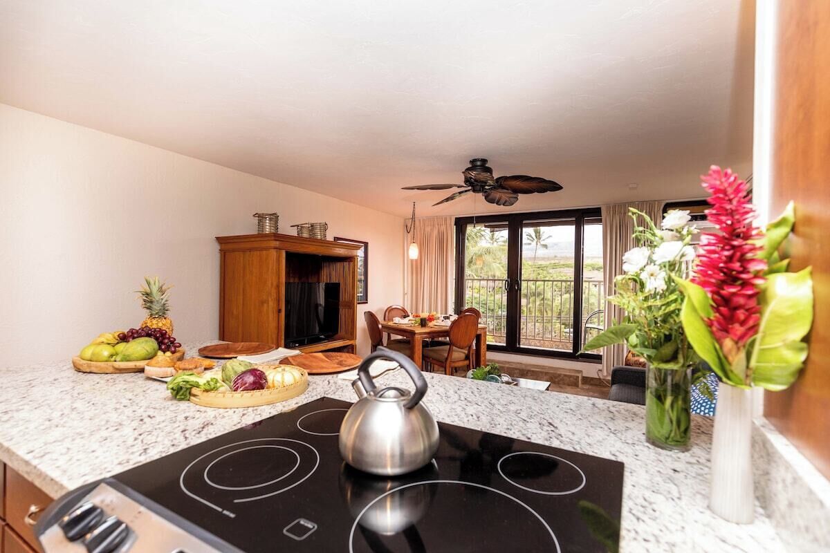 A modern kitchen with a black stove, wooden cabinets, and a dining area with a table and chairs.