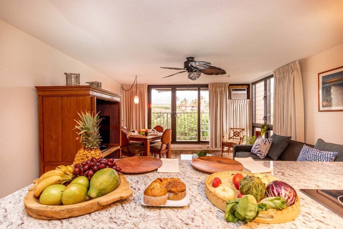 Un soggiorno con zona pranzo, ventola a soffitto e un'ampia finestra con tende.