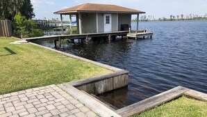 A dock extending into a calm lake with a small building on stilts. - Beautiful Newly Remodeled Home on Lake Santa Fe (Waldo)