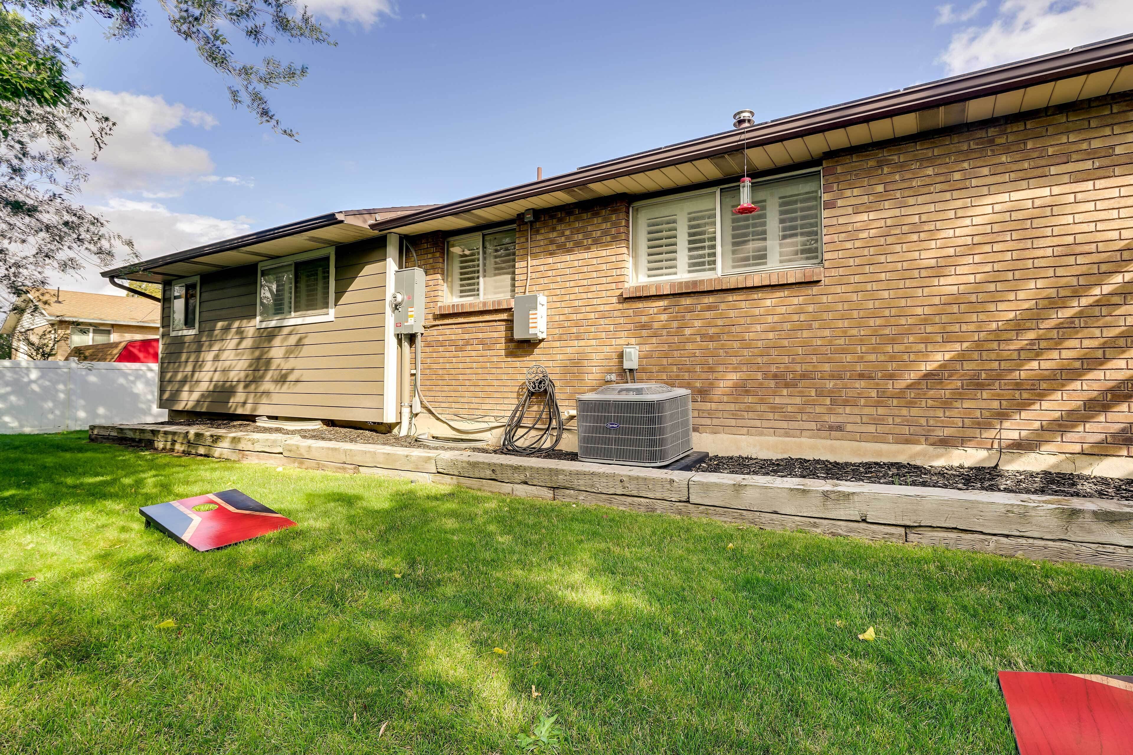 A residential house with a brick exterior, a lawn, and an air conditioning unit.