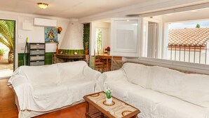 Una sala de estar acogedora con un sofá blanco, una mesa de centro de madera y una chimenea.