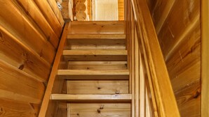 A wooden staircase with a handrail, leading to a higher level.