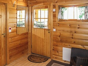 A wooden cabin interior with a door, a window, a doormat, and a radiator. - Tunturimaja 2 mökki by Interhome (Hyrynsalmi)