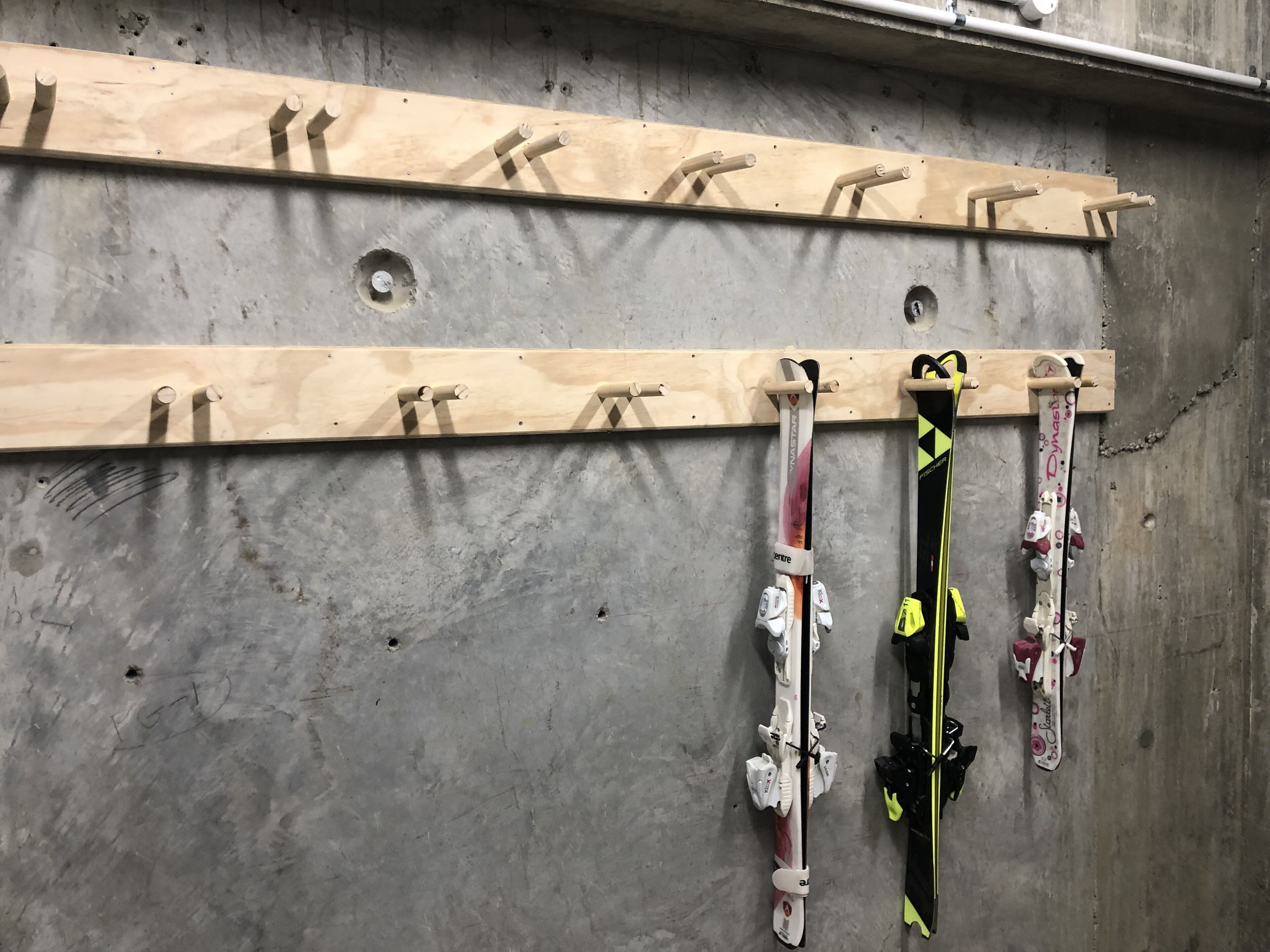 Eine wandmontierte Skiaufbewahrung mit mehreren Haken für Skier.