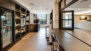 Une cuisine moderne dotée d’appareils électroménagers intégrés, d’un îlot central et offrant une vue sur l’extérieur.