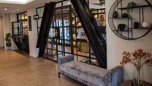 Un intérieur moderne avec un canapé, un escalier et une étagère murale agrémentée de plantes.