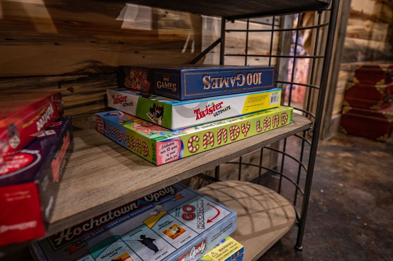 A shelf with various board games including 'Twister Ultimate' and 'Hogtown'.