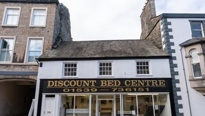 A building with a sign for a discount bed centre. - Highgate View Apartment -   Kendal Town Centre (Kendal)