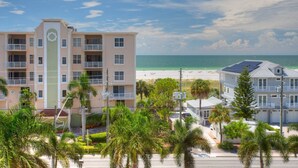 A beachfront hotel with multiple balconies, a pool area, and a view of the ocean. - Top Floor Waterfront Resort. Steps to the Beach,Pool, Hot Tub, Dock, Great View +Tickets to Fun! (Treasure Island)