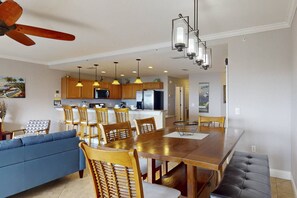 A modern kitchen with wooden cabinets, a central island, and pendant lighting.