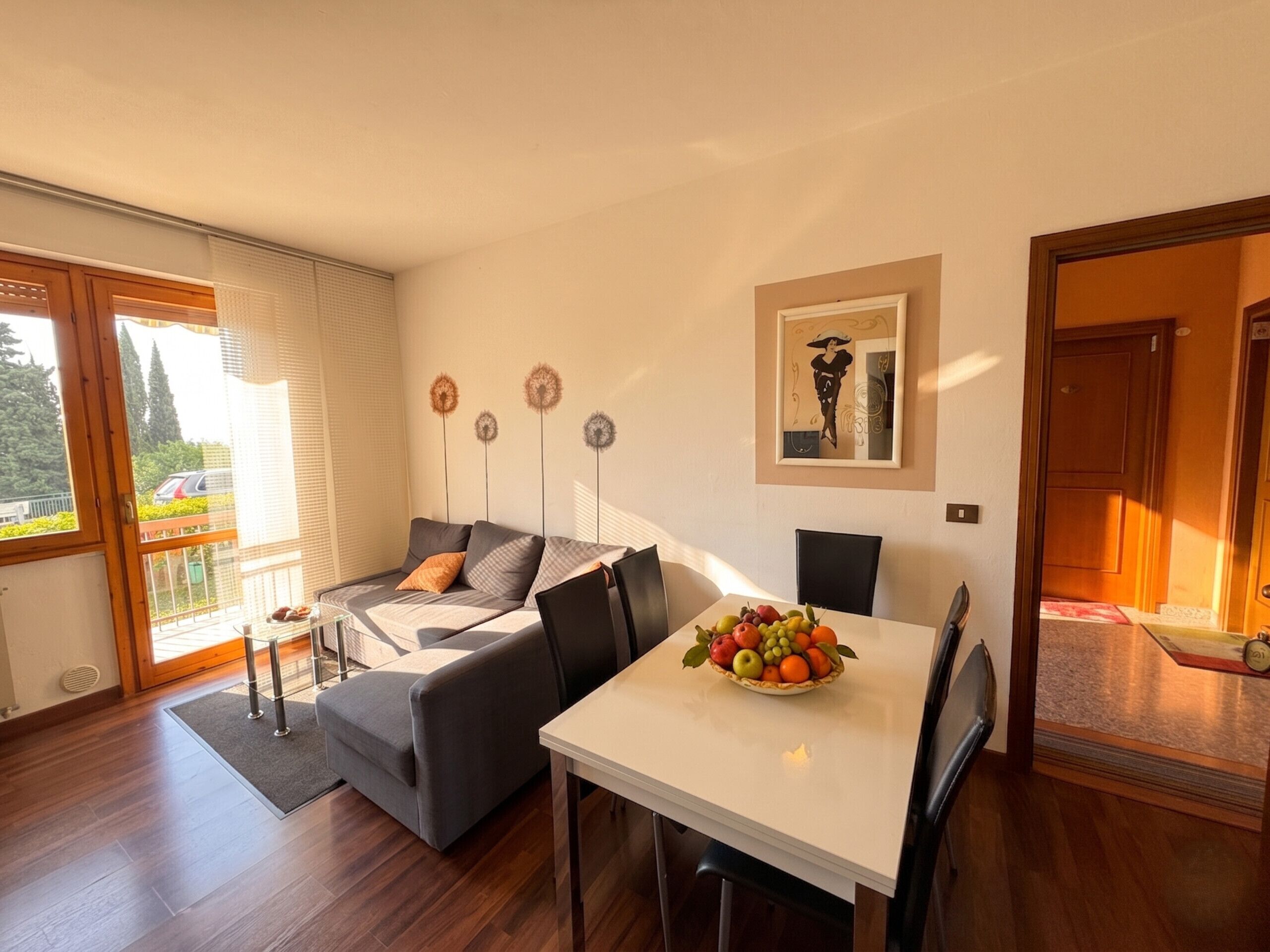 A modern living room with a sofa, dining table, and a fruit bowl.