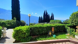 A well-maintained garden with neatly trimmed hedges, a stone pathway, and a statue. - Appartamento Tobias 201 La Portella (Tignale)