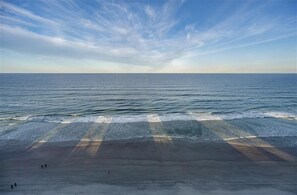 Een strand met heldere lucht en een rustige zee.
