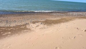 Ein Strand mit Kiesküste und ruhigem Wasser.