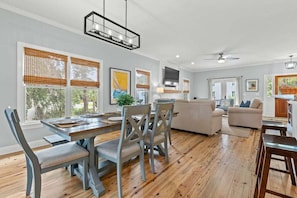 A spacious living area with a dining table, multiple chairs, a sofa, and a TV. - Seabrook Village! Amenity access available for purchase!! Pet Friendly! (Seabrook Island)