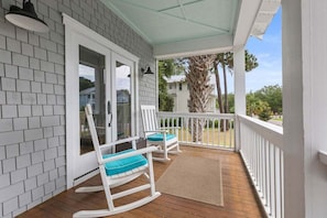 A covered porch with rocking chairs, a wooden floor, and a view of the surrounding area. - Seabrook Village! Amenity access available for purchase!! Pet Friendly! (Seabrook Island)