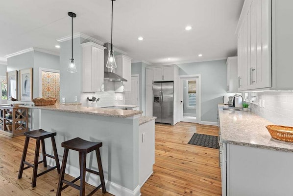 A modern kitchen with white cabinets, a central island with stools, and a stainless steel refrigerator. - Seabrook Village! Amenity access available for purchase!! Pet Friendly! (Seabrook Island)
