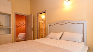 A bedroom with a bed, a wardrobe, and a bathroom visible through an open door. - Comfortable Apartment Vittorio in Agriturismo Colleincanto (Gavardo)