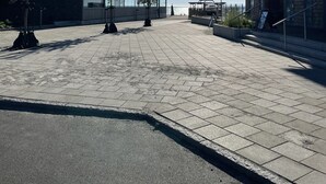 Tilava ulkoalue, jonka yllä on avoin taivas, ja jossa on moderneja rakennuksia sekä muutama puu.