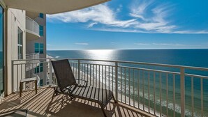 A balcony with a view of the ocean, a chair, and a small table. - Aqua 3br/3ba. 2 Master BD ocean view (Panama City Beach)