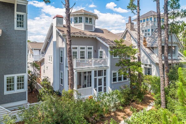 A two-story house with a balcony and a wrap-around porch.
