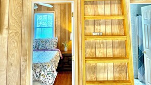 A loft-style bedroom with a wooden slat ladder leading to a lofted sleeping area. - Walking Distance to Lake James: Private Resort Amenities  (Marion)