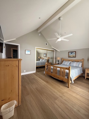 Ein Schlafzimmer mit zwei Betten, einem Deckenventilator und Holzboden.