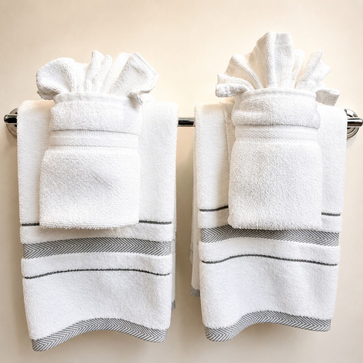 Two white towels with a chevron pattern hanging on a rack.