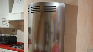 Une cuisine équipée d’une cuisinière encastrée, d’un four à micro-ondes et d’un grille-pain posé sur le plan de travail.